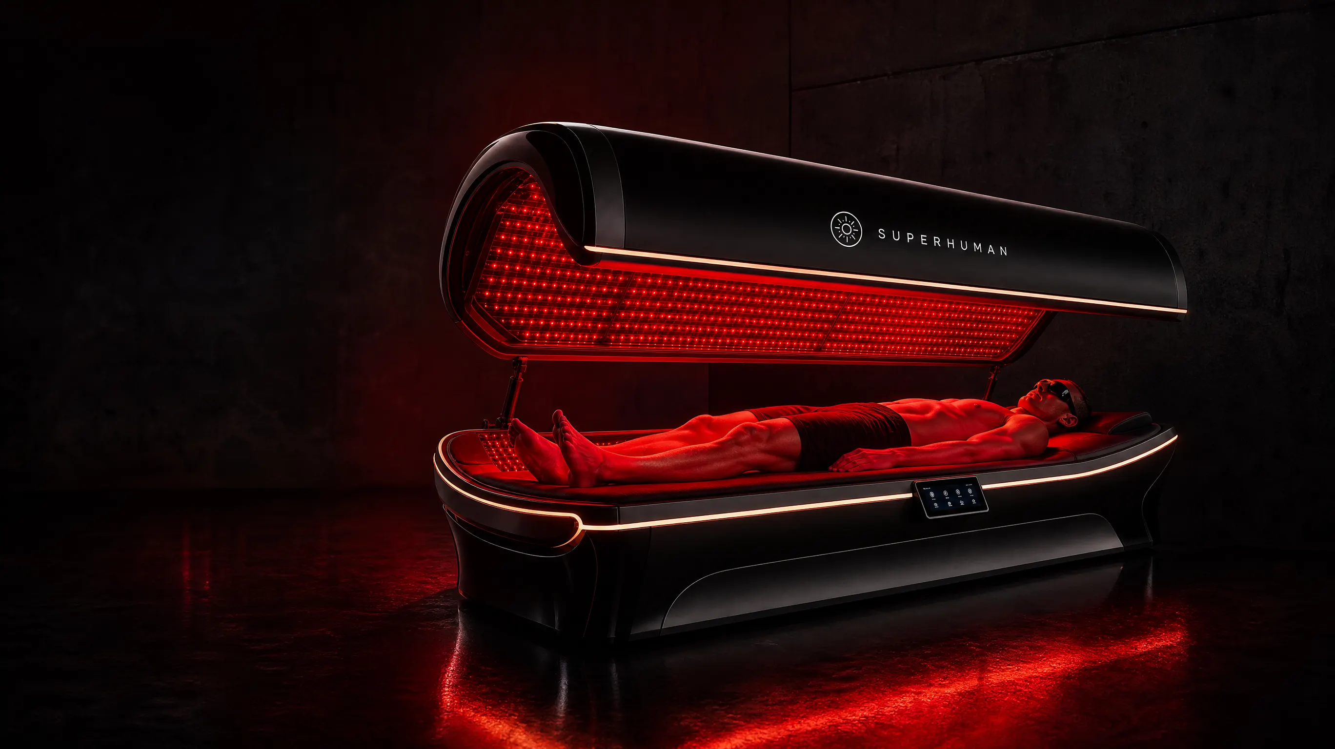 Superhuman Light R1 red light therapy bed glowing red in a dark studio